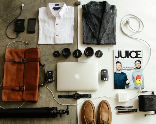 Top 7 must-have travel items for 2025 displayed on a suitcase: foldable backpack, TSA-approved toiletry bag, packing cubes, and more from UK brands